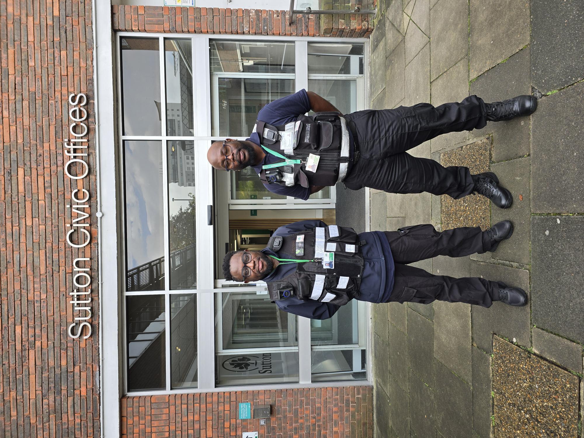 Two enforcement officers in uniform standing infront of the civic offices